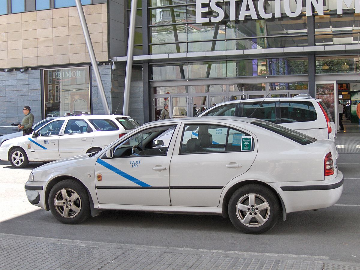 Málaga taxis are white with a blue lateral stripe.