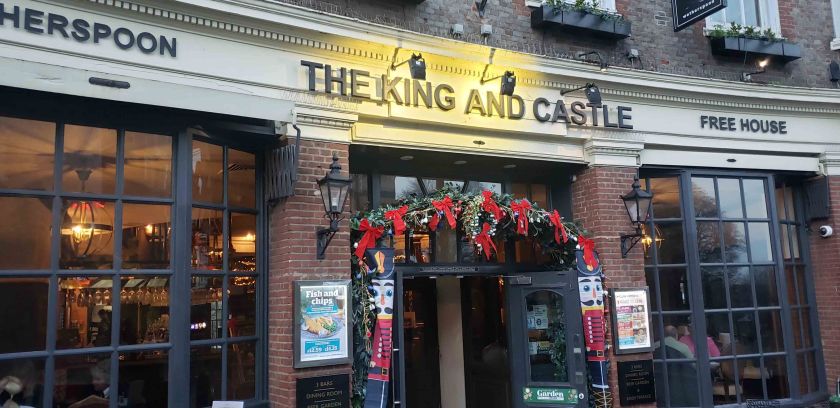 Exterior view of The King and Castle pub in Windsor, adorned with festive decorations and a welcoming entrance.